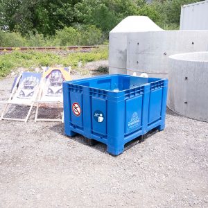 Blaue Bigbox des Workerpools im Außenbereich auf Schotterfläche mit weißem Logo und Sicherheitsaufklebern
