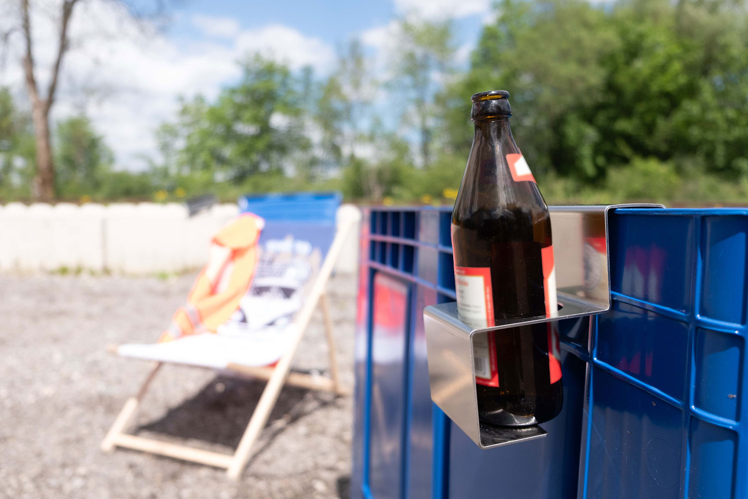 Flaschenhalter aus Metall mit eingesetzter Trinkflasche an einem Workerpool-Arbeitsplatz.
